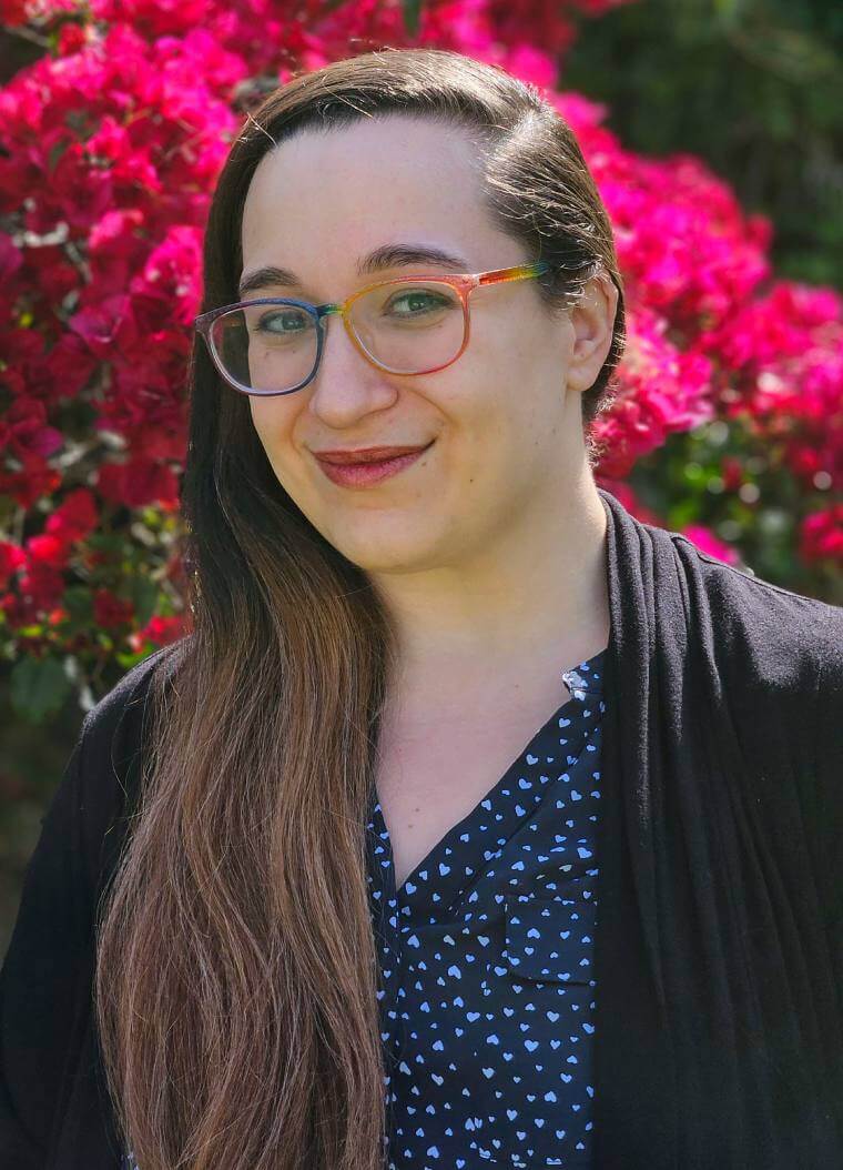 Victoria Garcia standing in front of red flowers
